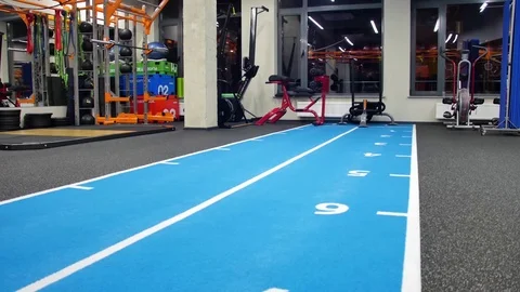 Rear view strong man flipping tyre while practising in Crossfit gym lifting a Stock Footage 75209761