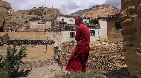 Rear view of a Tibetan monk looking at the village Stock Footage 62923901