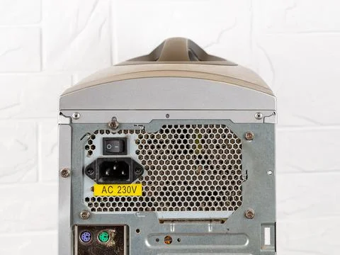 Rear view of tower computer case with dusty faulty power supply unit. Stock Photos