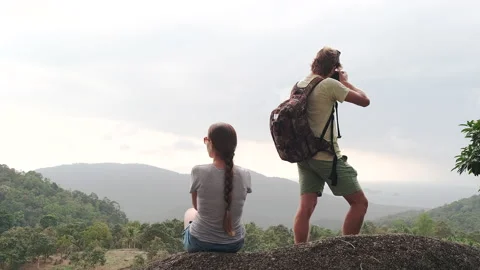 Rear view of two hikers with backpacks on the background of mountains Stock Footage 139970901