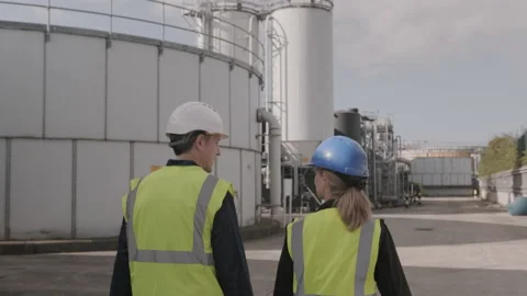 Rear view on two industrial workers walking on industrial plant wearing Stock Footage 139944665