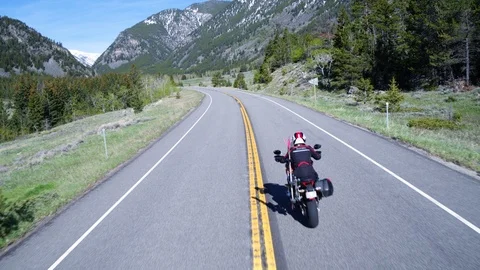 Rear view of two motorcyclists riding through mountainous highway, Wyoming USA Stock Footage 124220866
