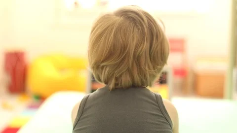 Rear view of two years old boy using modern notebook looking movies on laptop 스톡 동영상 109297236