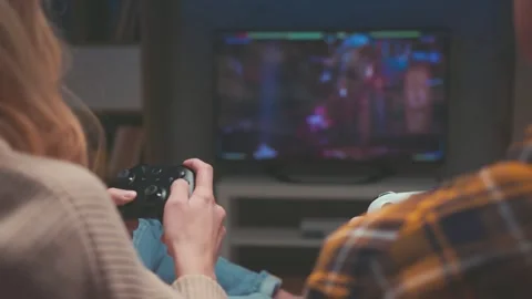 Rear View of Unrecognizable Couple Playing Videogame with White and Black Gamepa Stock Footage 337449850
