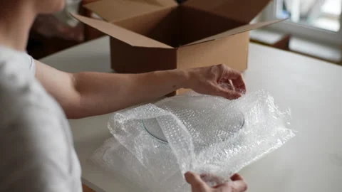 Rear view of unrecognizable man pack up breakable fragile glassware into Stock Footage 267642343