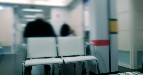 Rear view of unrecognizable persons sitting on the bench in doctors waiting room Stock Footage 171541675