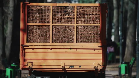 Rear view of a utility trailer filled with branches and organic material in a Stock Footage 332572898