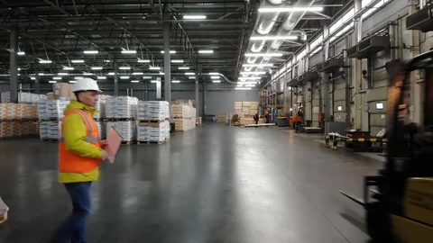 Rear view of warehouse team discussing while walking in warehouse. Aerial, top Video stock 101229247