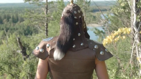 Rear view of warrior in old armor with fur that goes forest in summer. Vídeos de archivo 81405637