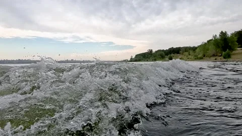 Rear view of the waves behind a fast-moving boat moving rapidly along the e.. Stock Footage 272299710