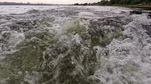 Rear view of the waves behind a fast-moving boat moving rapidly along the e.. Stock Footage 273197954