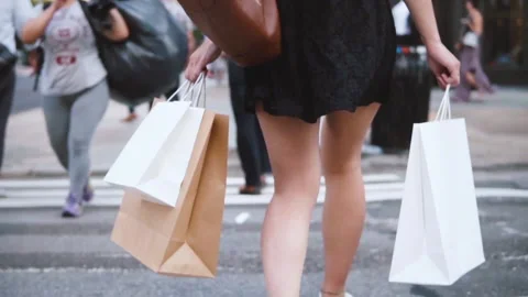 Rear view of a woman carrying shopping bags, slow motion Stock Footage