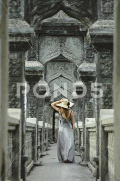 Rear view of woman in dress while walking on bridge at Karangasem water temple Stock Photos