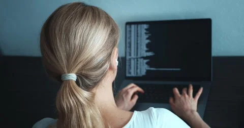 Rear view of woman programmer sitting in front of laptop computer monitor and Stock Footage 244763916