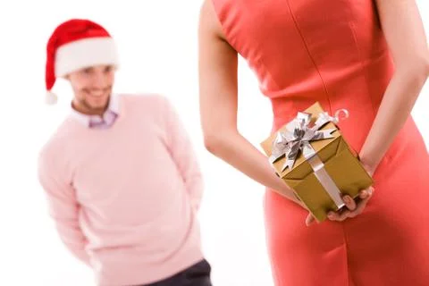 Rear view of woman in red dress holding giftbox in hand on background of her hus Stock Photos