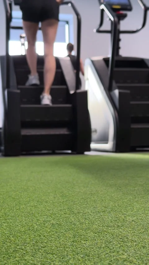 Rear view of woman using stair climber in gym Stock Footage 330135570
