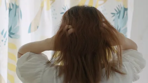Rear view of a woman's scratching her scalp intensely, indicating an itchy scalp Stock Footage 327847145