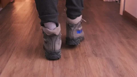 Rear view of worker in rugged boots walking along dimly lit apartment hallway Stock Footage 333651053