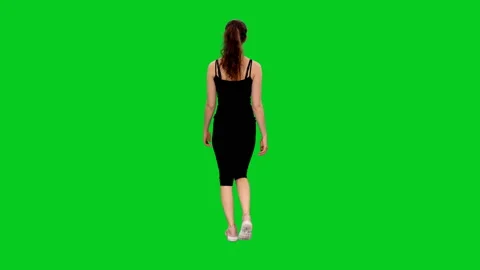 Rear view of young attractive slim sporty woman walking against green screen 스톡 동영상 130001751