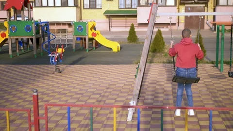 Rear view, young bald happy woman swinging on a swing at the playground Stock Footage 119666802