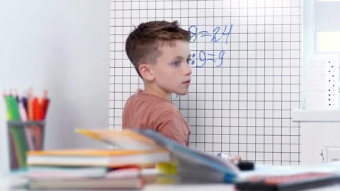 Rear view of young boy solving math problems on white board. Stock Footage 277934799