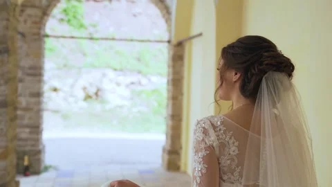 Rear view of the young charming bride walking and looking around. Slow motion Stock Footage 211398312