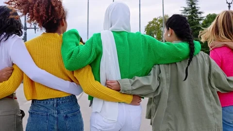 Rear view of young group of diverse women walking together embracing outdoors. Vidéo 276836904
