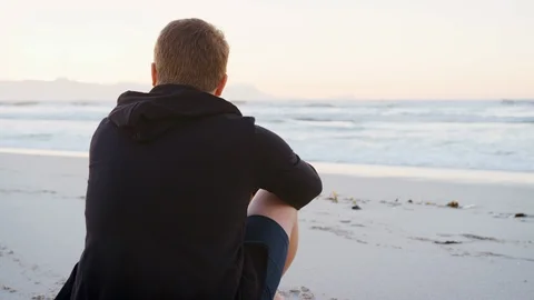 Rear View Of Young Man On Beach Watching Sun Rise Over Ocean Stock Footage 95501699