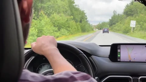 Rear View of a Young Man Driving a Car in Motion on a Country Road Stock Footage 249099264
