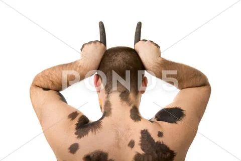 Rear view of young man with painted spots showing horns on white background Stock Photos