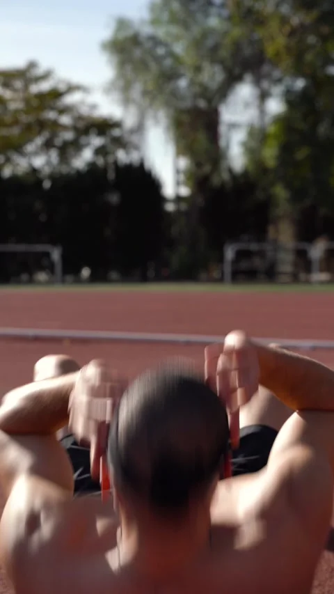 Rear view of a young man performing sit-ups. Vertical video. Concept of tra.. Stock Footage 267894477