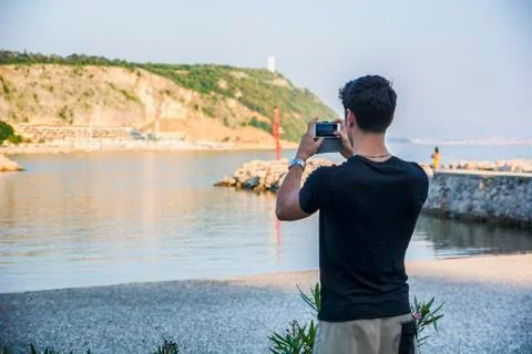 Rear View of Young Man Taking Photos at the Beach Stock Photos