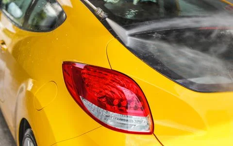 Rear window and red back light of yellow  car washed in self serve carwash, j Stock Photos