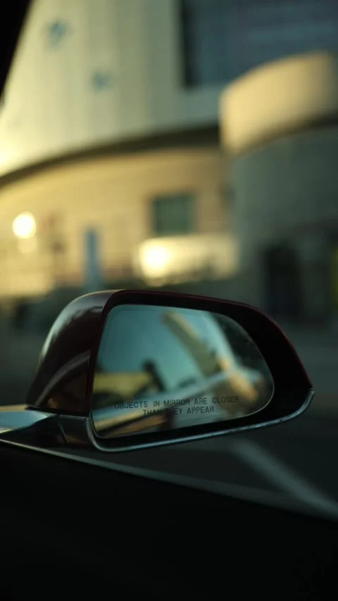 Rearview mirror captures urban driving through a busy city street Stock Footage 346545802