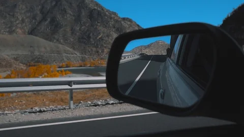 	Rearview mirror gray car. View from moving car during trip in desert road Stock Footage 103455925