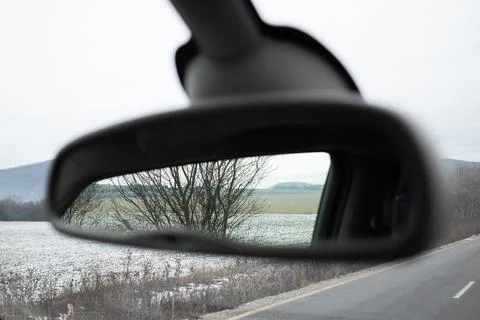Rearview mirror reflection of nature set against a beautiful winter scenery. Stock Photos