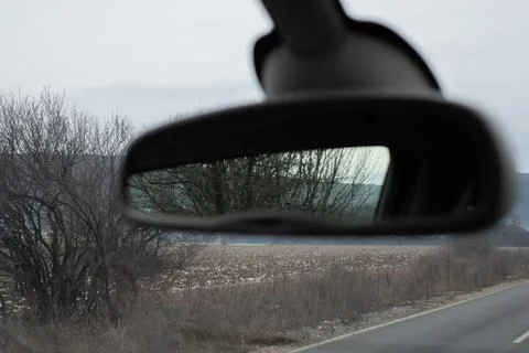 Rearview mirror reflection of nature set against a beautiful winter scenery. Stock Photos