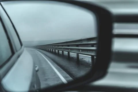 Rearview mirror with road reflection. Image in motion. Black and white image Stock Photos