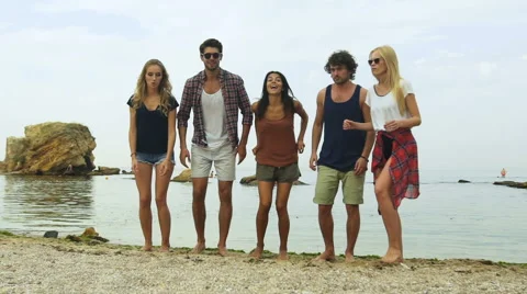 Rearview shot of a group of friends jumping into mid-air on the beach Stock Footage 68798612
