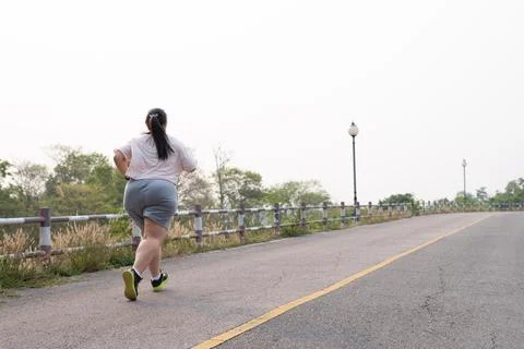 Rearview of unrecognizable plus-size, fat Asian woman running Foto stock