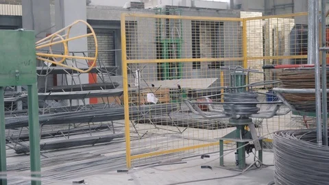 Rebar spool rotates on support supplying welding machine Stock Footage 124003083