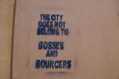 Rebellious black graffito on orange wall Stock Photos