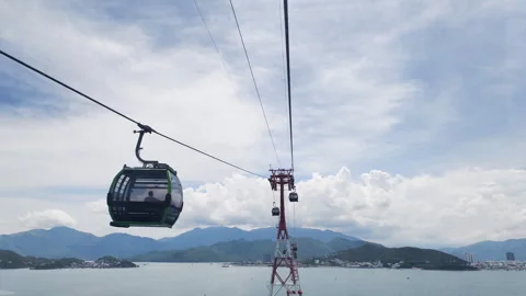 A receding cable car cabin against a backdrop of mountains and sea. Stock Footage 317760523