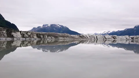 Receding glacier with reflective lake in remote natural landscape Stock Footage 332186845