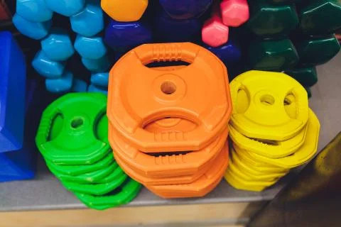 Receding row of weights lined up in a gym waiting for clients with focus to the Stock Photos