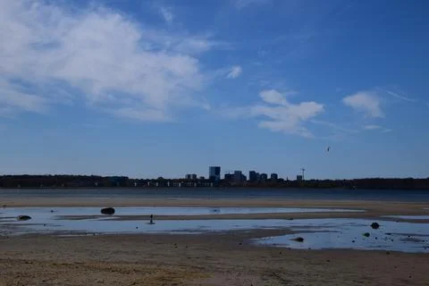Receding Tide Exposing Sandy Mudflat and Shallow Water near Harbor Stock Photos