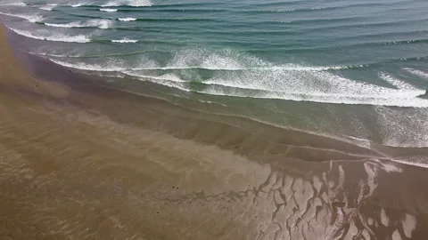 The receding tide reveals a pattern of sandbars and ripples on the beach. Vídeos de archivo 289442198