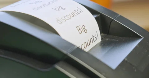 Receipt printer prints text: big discounts. Close-up, side view. The concept of Stockbeeldmateriaal 213219212