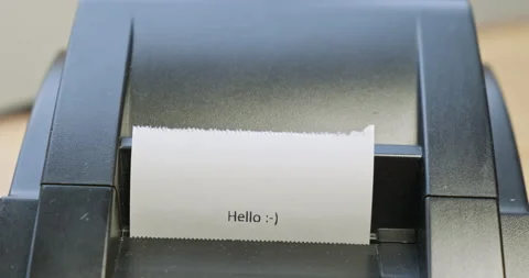 Receipt printer prints text: hello, what would you like to buy. Close-up, front Vídeos de archivo 218767021
