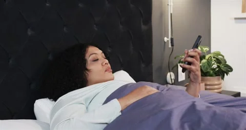 Receiving buzzing notification, woman in bed grabbing smartphone from hook and Stock Footage 317642386
